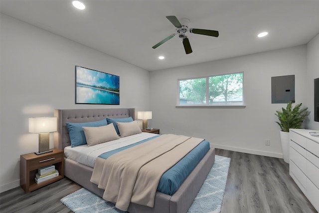 bedroom featuring baseboards, electric panel, and wood finished floors