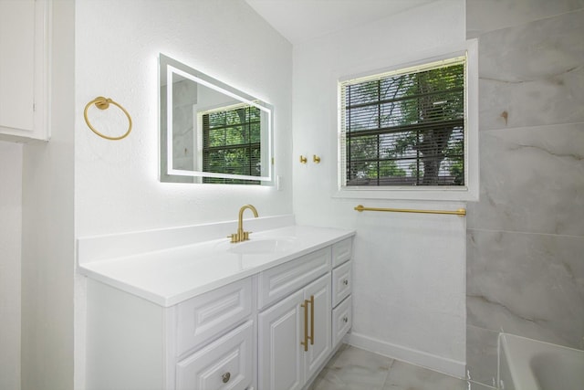 full bathroom featuring a tub, vanity, and a healthy amount of sunlight