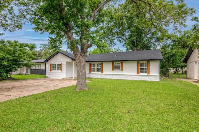 ranch-style home with a front lawn and concrete driveway
