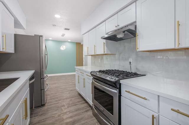kitchen with under cabinet range hood, white cabinets, backsplash, and appliances with stainless steel finishes