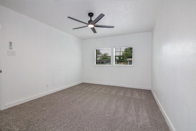 carpeted spare room featuring ceiling fan and baseboards