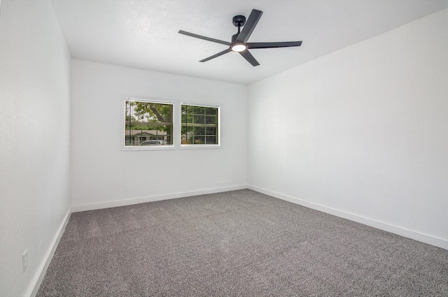carpeted spare room with baseboards and a ceiling fan