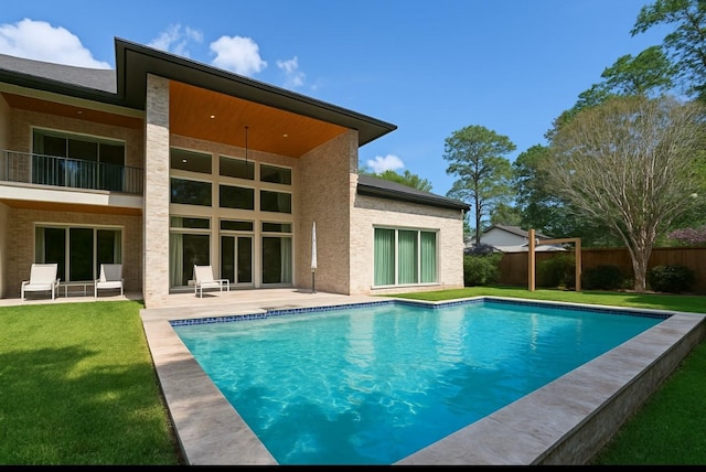 13927 Perthshire Rd, Houston, TX 77079 - rear view of house featuring fence, a fenced in pool, a patio area, a balcony, and a yard