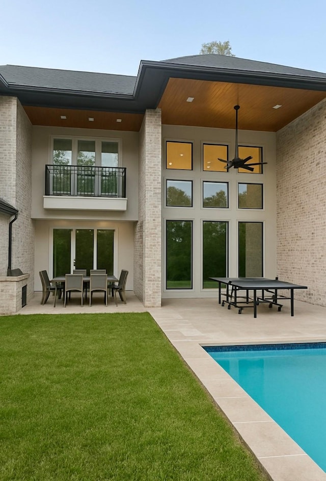 13927 Perthshire Rd, Houston, TX 77079 - rear view of property with an outdoor pool, a patio area, a balcony, a yard, and stucco siding