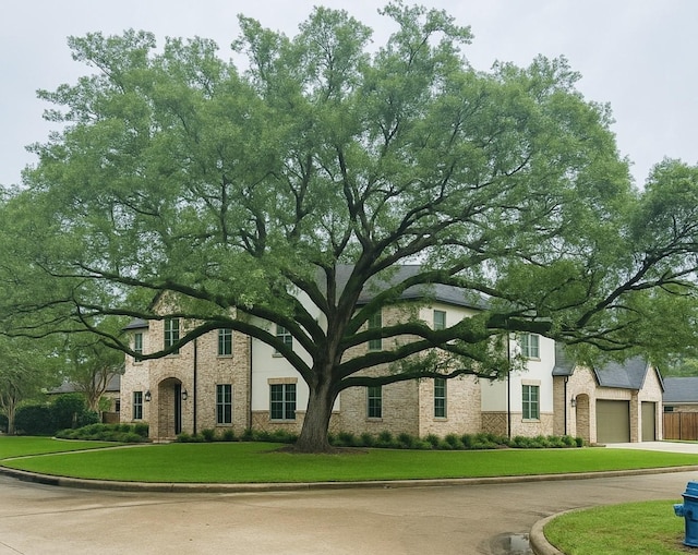 13927 Perthshire Rd, Houston, TX 77079 - view of front of home featuring a garage, driveway, and a front lawn