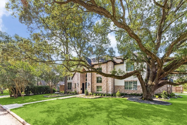13927 Perthshire Rd, Houston, TX 77079 - view of front of house featuring a front yard, brick siding, and stucco siding