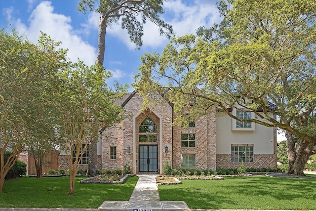 13927 Perthshire Rd, Houston, TX 77079 - view of front of home featuring brick siding, a front lawn, and stucco siding