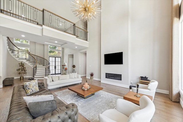 13927 Perthshire Rd, Houston, TX 77079 - living room with stairway, baseboards, a towering ceiling, wood finished floors, and a glass covered fireplace