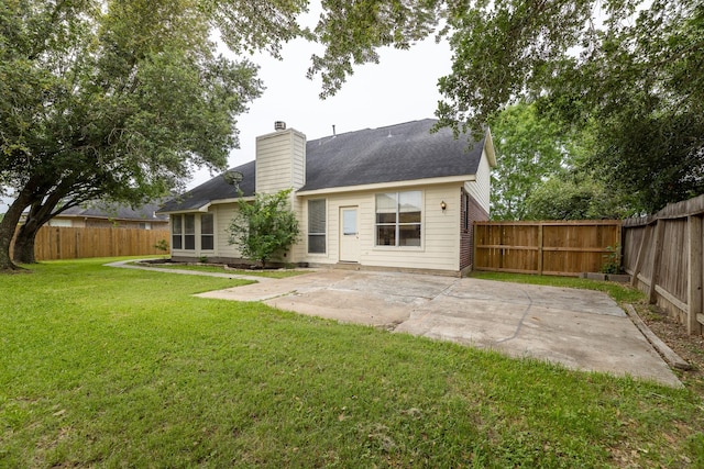 rear view of property featuring a fenced backyard, a patio, a chimney, and a yard
