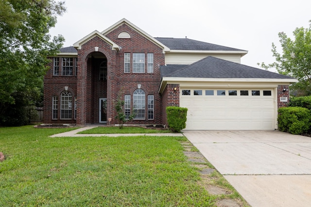 traditional-style home featuring brick siding, an attached garage, driveway, and a front yard