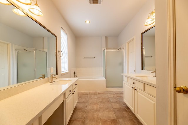 bathroom featuring two vanities, a shower stall, a sink, and a garden tub