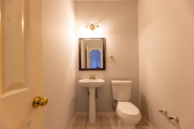 half bathroom with baseboards, tile patterned flooring, and toilet