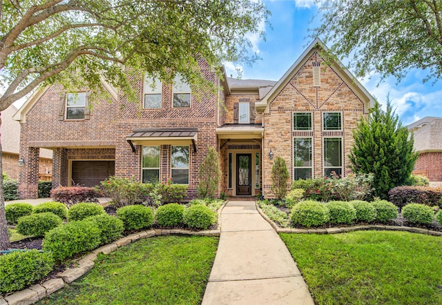 view of front of property with brick siding, an attached garage, and a front yard