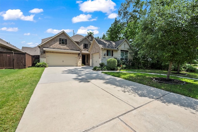 view of front of house featuring fence, stone siding, a front lawn, concrete driveway, and an attached garage