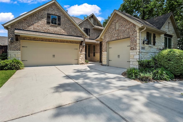 view of front of house featuring a garage, roof with shingles, concrete driveway, and stone siding