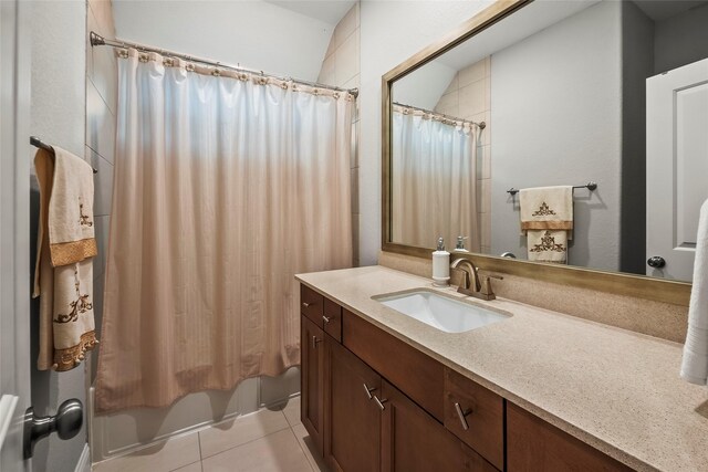 bathroom with tile patterned flooring, shower / bathtub combination with curtain, and vanity