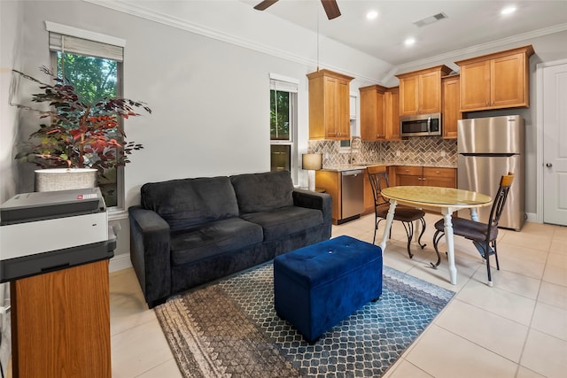 living room featuring a wealth of natural light, visible vents, a ceiling fan, and ornamental molding