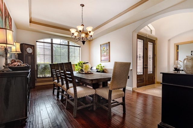 6310 Indiangrass Ct, Katy, TX 77494 - dining room with arched walkways, dark wood finished floors, a chandelier, and a tray ceiling