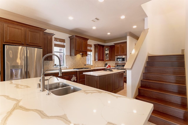 6310 Indiangrass Ct, Katy, TX 77494 - kitchen with a center island, a sink, crown molding, appliances with stainless steel finishes, and tasteful backsplash