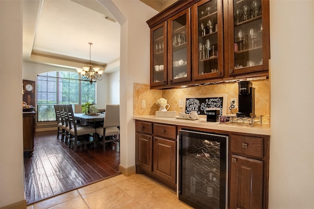6310 Indiangrass Ct, Katy, TX 77494 - bar with a tray ceiling, beverage cooler, baseboards, arched walkways, and backsplash