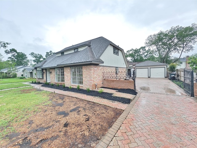 view of side of property with an outdoor structure, a shingled roof, fence, a yard, and brick siding