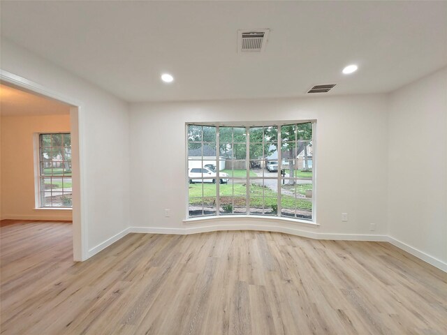 empty room with recessed lighting, visible vents, wood finished floors, and baseboards