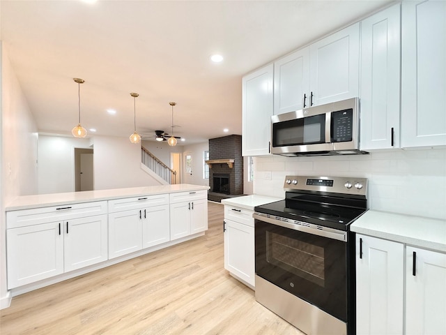 kitchen featuring decorative backsplash, appliances with stainless steel finishes, light countertops, light wood-type flooring, and recessed lighting