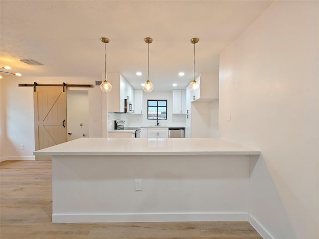 kitchen with stainless steel appliances, white cabinets, a sink, baseboards, and visible vents