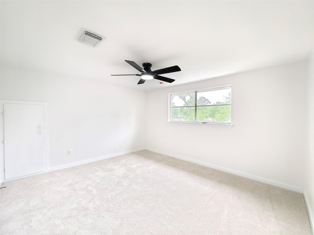 carpeted empty room with visible vents, ceiling fan, and baseboards