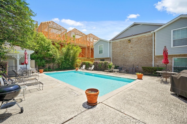 pool featuring fence, a patio area, and area for grilling