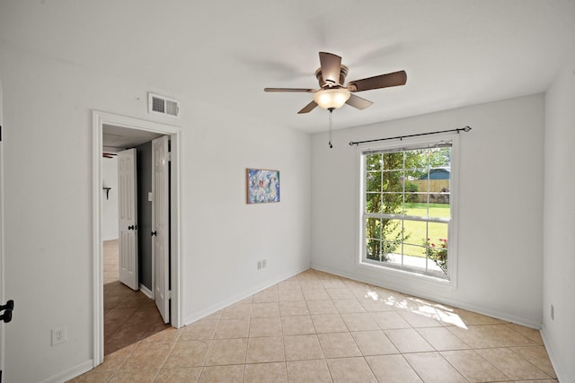 spare room with a ceiling fan, baseboards, visible vents, and light tile patterned floors