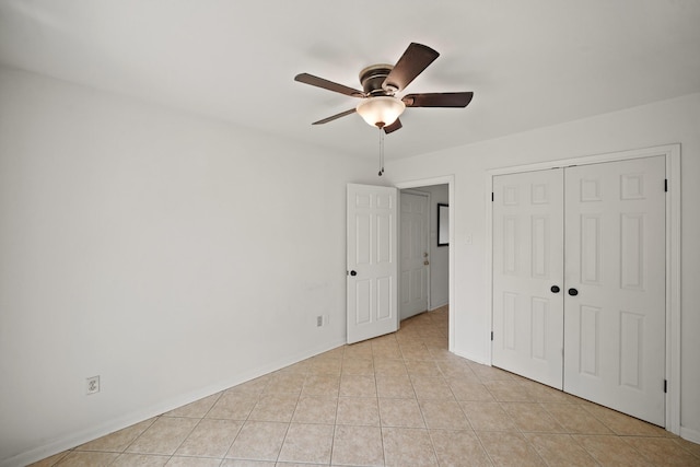 unfurnished bedroom with a closet, baseboards, ceiling fan, and light tile patterned flooring