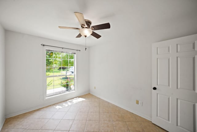 unfurnished room featuring baseboards, ceiling fan, and light tile patterned flooring
