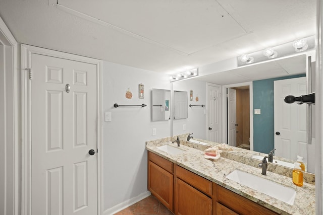 full bath with toilet, double vanity, tile patterned floors, and a sink