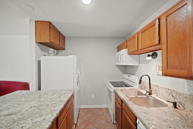 kitchen featuring white appliances, baseboards, brown cabinets, a sink, and light tile patterned floors