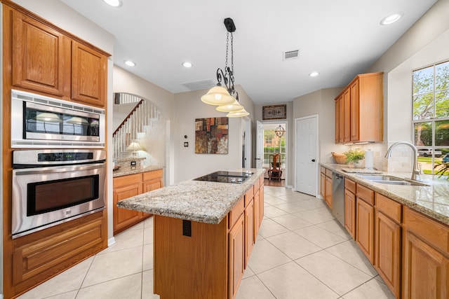 kitchen with a sink, stainless steel appliances, light tile patterned floors, a kitchen island, and visible vents