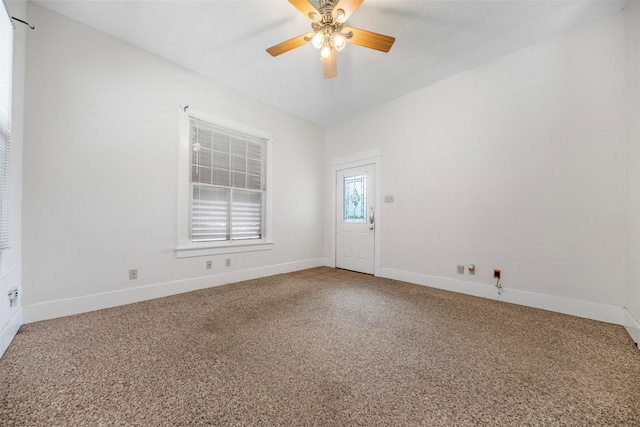 spare room with a ceiling fan, baseboards, and light carpet