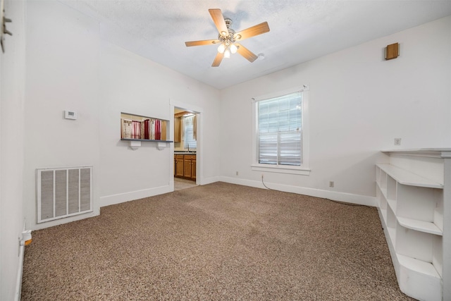 interior space with carpet flooring, baseboards, visible vents, and ceiling fan