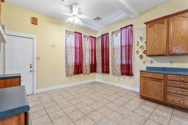kitchen featuring dark countertops, ceiling fan, brown cabinets, and visible vents
