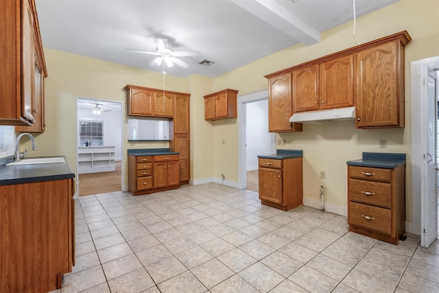 kitchen featuring brown cabinets, a ceiling fan, and a sink