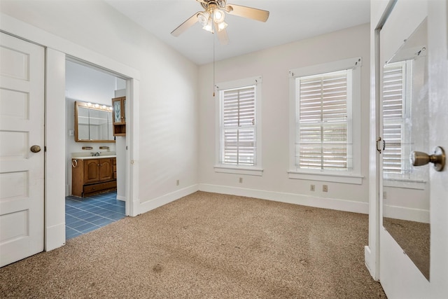 unfurnished bedroom with carpet floors, baseboards, and connected bathroom