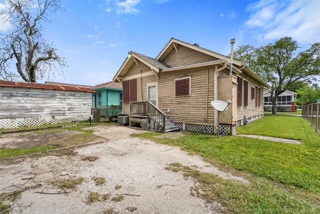 view of front facade featuring central AC unit, fence, and a front yard