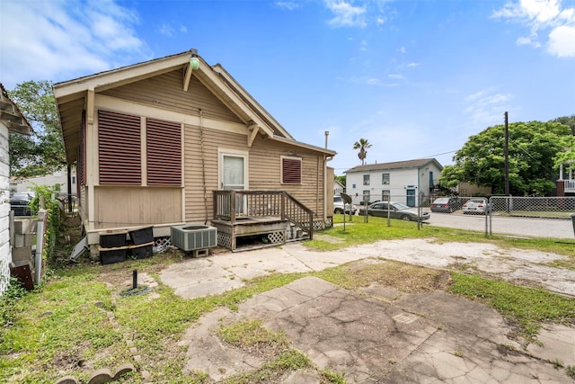 rear view of property featuring central AC and fence
