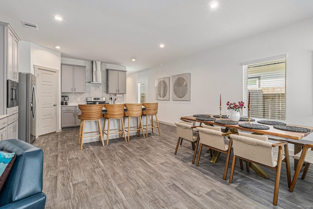 dining space with recessed lighting, light wood-style flooring, and visible vents