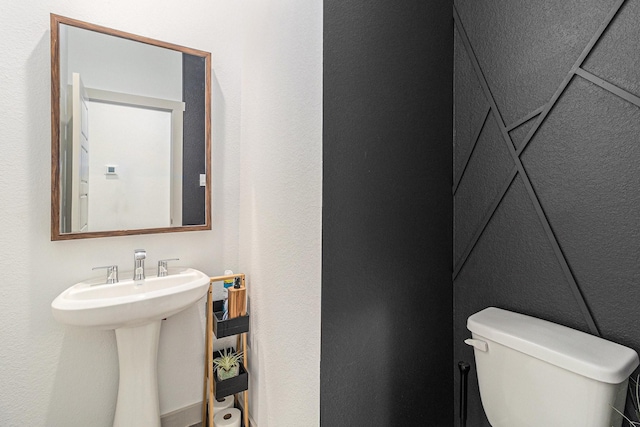 bathroom with a textured wall and toilet