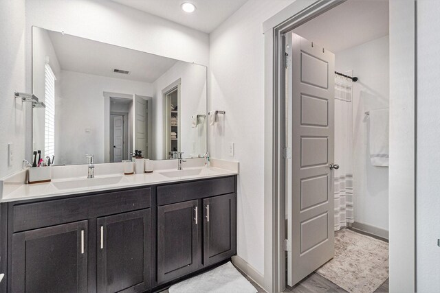 12823 Tokenhouse Ln, Houston, TX 77047 - full bath with double vanity, a shower with curtain, baseboards, and wood finished floors