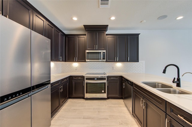 kitchen featuring visible vents, light countertops, tasteful backsplash, a sink, and appliances with stainless steel finishes