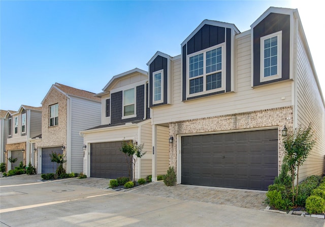 view of property with an attached garage, board and batten siding, and driveway