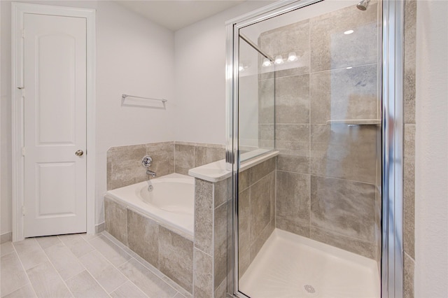 bathroom with tile patterned floors, a stall shower, and a garden tub