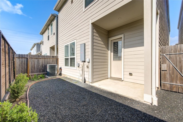 back of house featuring central AC, a fenced backyard, and a patio area